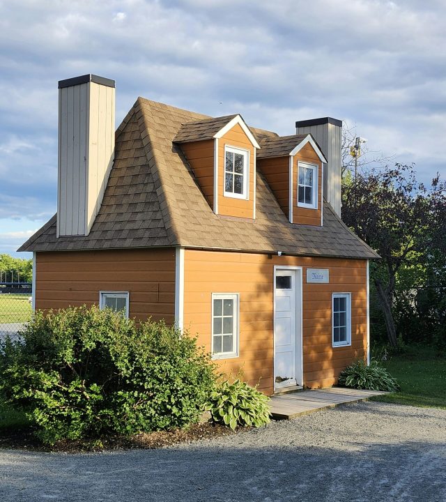 A quaint miniature house set against a scenic backdrop in Laval, Québec. Perfect for creative architectural concepts.